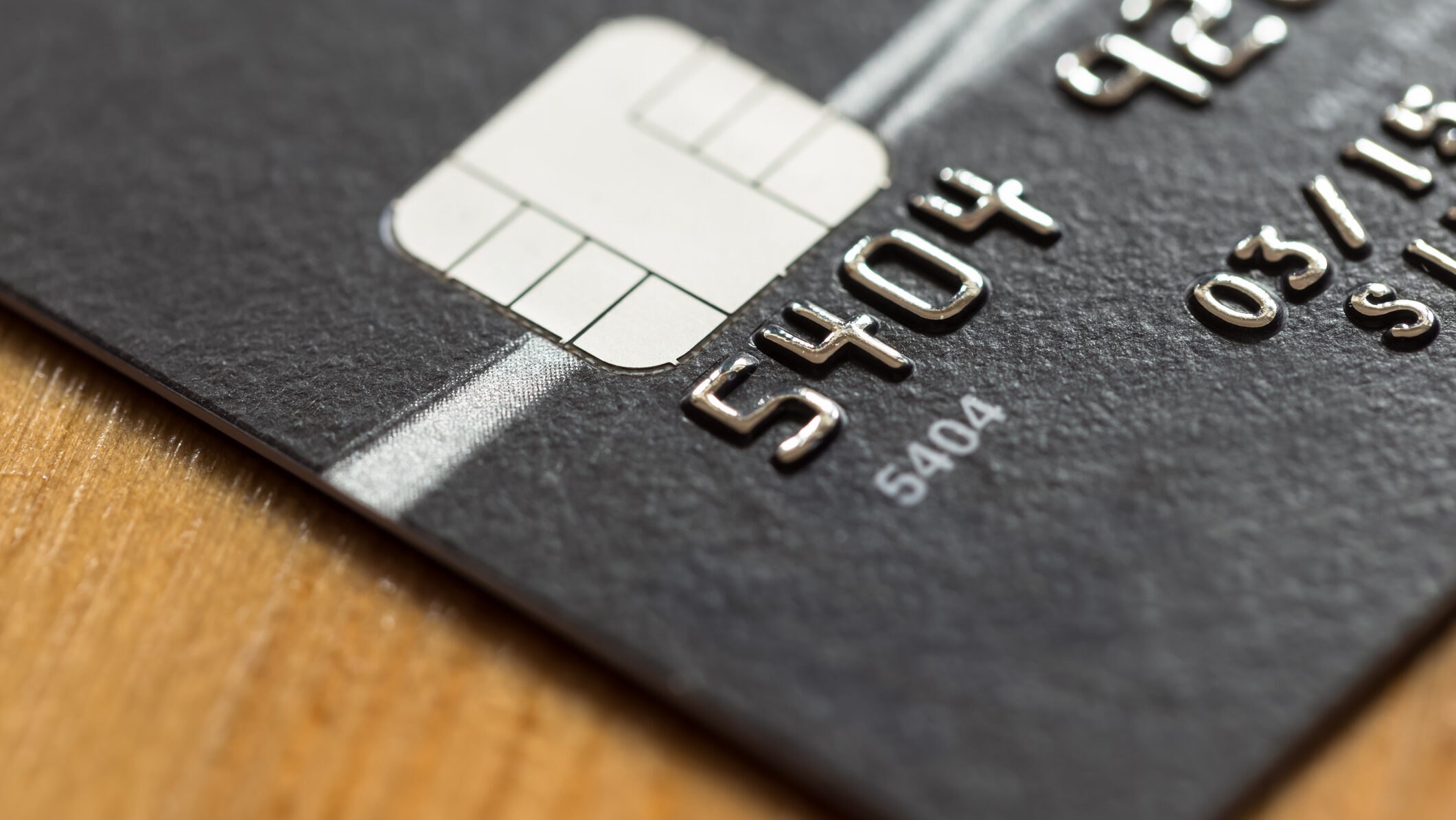 Black credit card on wooden desk